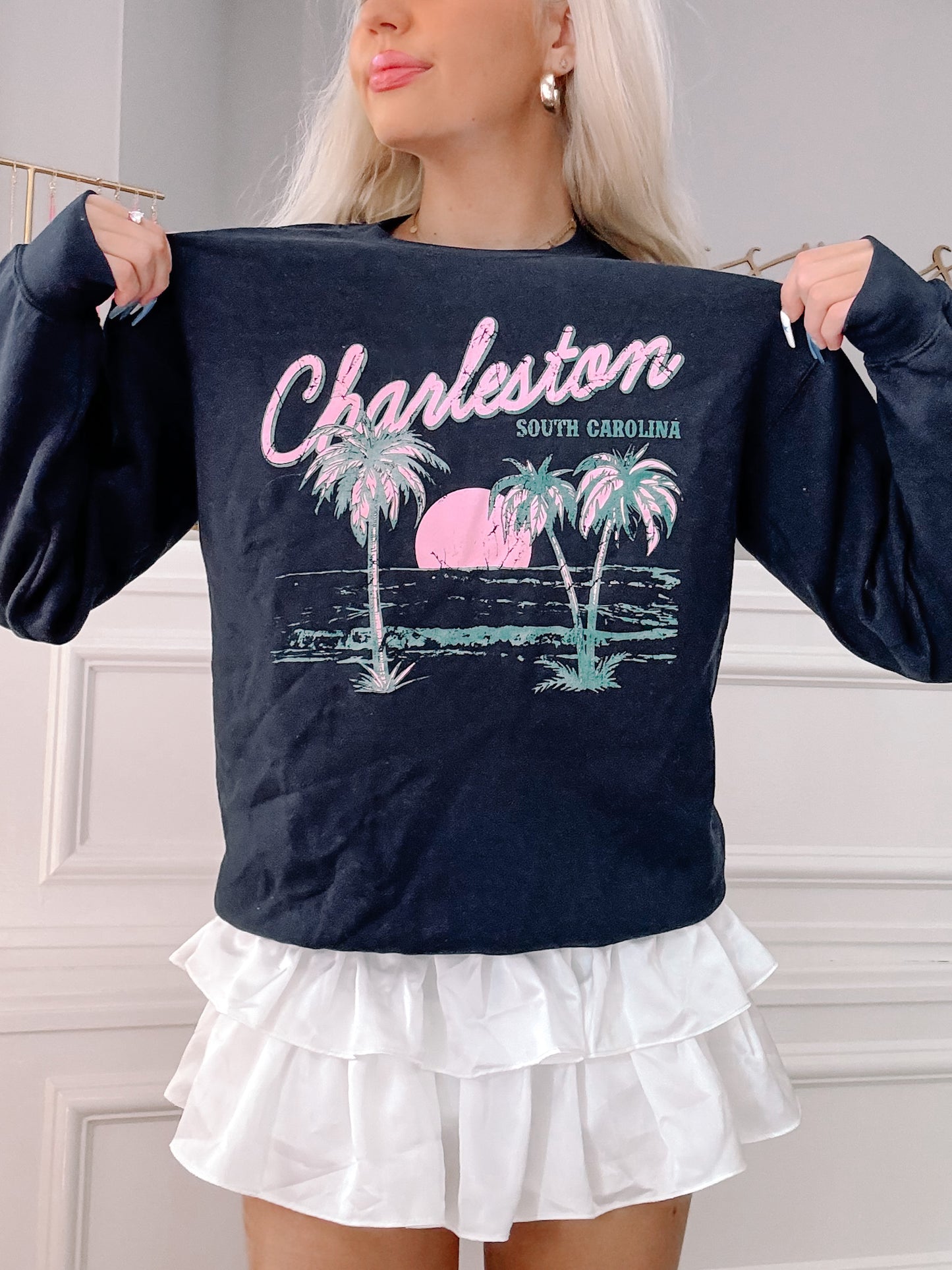 Navy blue crewneck sweatshirt featuring a palm tree and sunset graphic, "Charleston, South Carolina".
