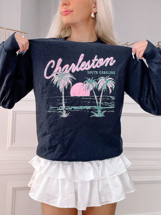 Navy blue crewneck sweatshirt featuring a palm tree and sunset graphic, "Charleston, South Carolina".
