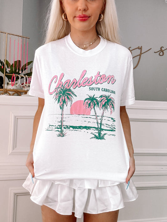 White tee featuring a palm tree and ocean scene graphic, "Charleston, South Carolina" text.