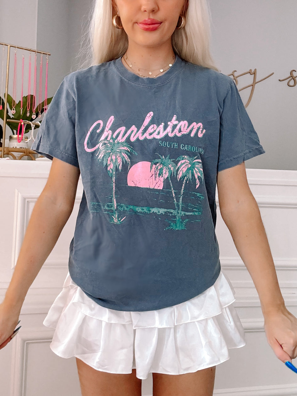 Charleston Tee | Slate Grey:  Slate grey tee featuring Charleston, South Carolina graphic with palm trees and sunset.
