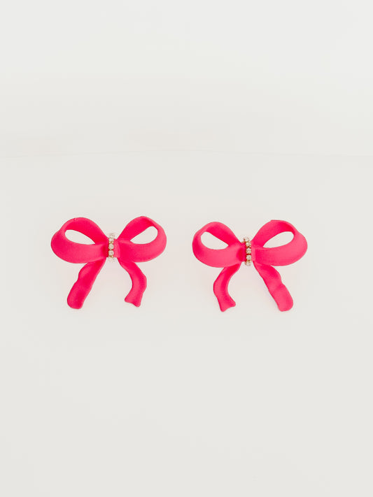 Pink bow earrings with rhinestone accents against a white background.