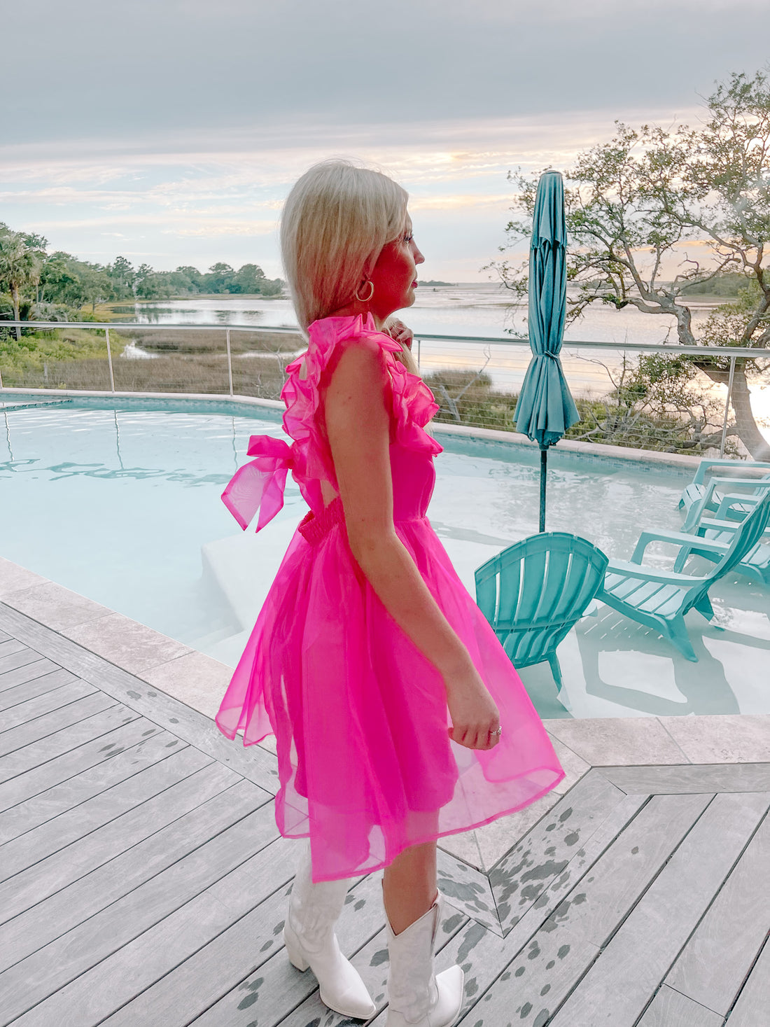 Hot pink mini dress with ruffle sleeves, worn poolside.
