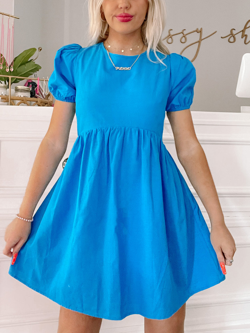 Electric blue mini dress with puff sleeves, showcased on a model.

