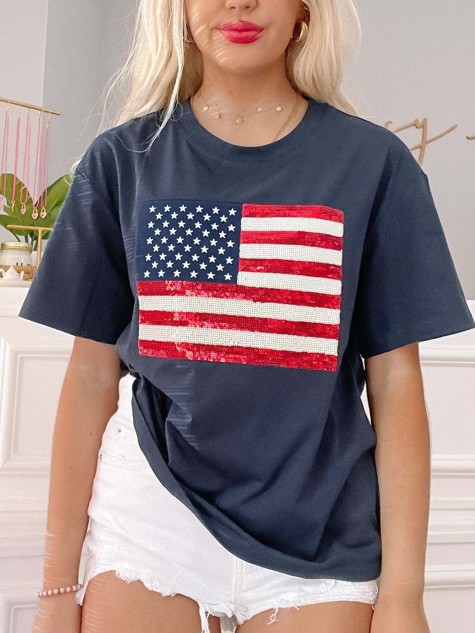Sequin-embellished American flag graphic on a navy blue oversized tee shirt.
