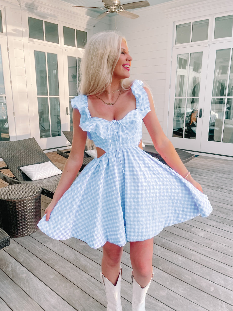 Life in the Dreamhouse blue gingham mini dress with ruffle sleeves and cutout detail.
