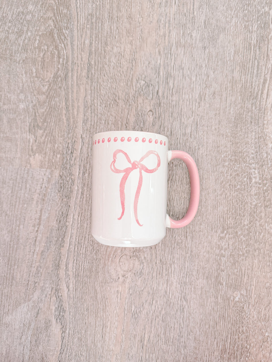 Big Bow Mug: Pink-trimmed ceramic mug featuring a watercolor-style pink bow design.
