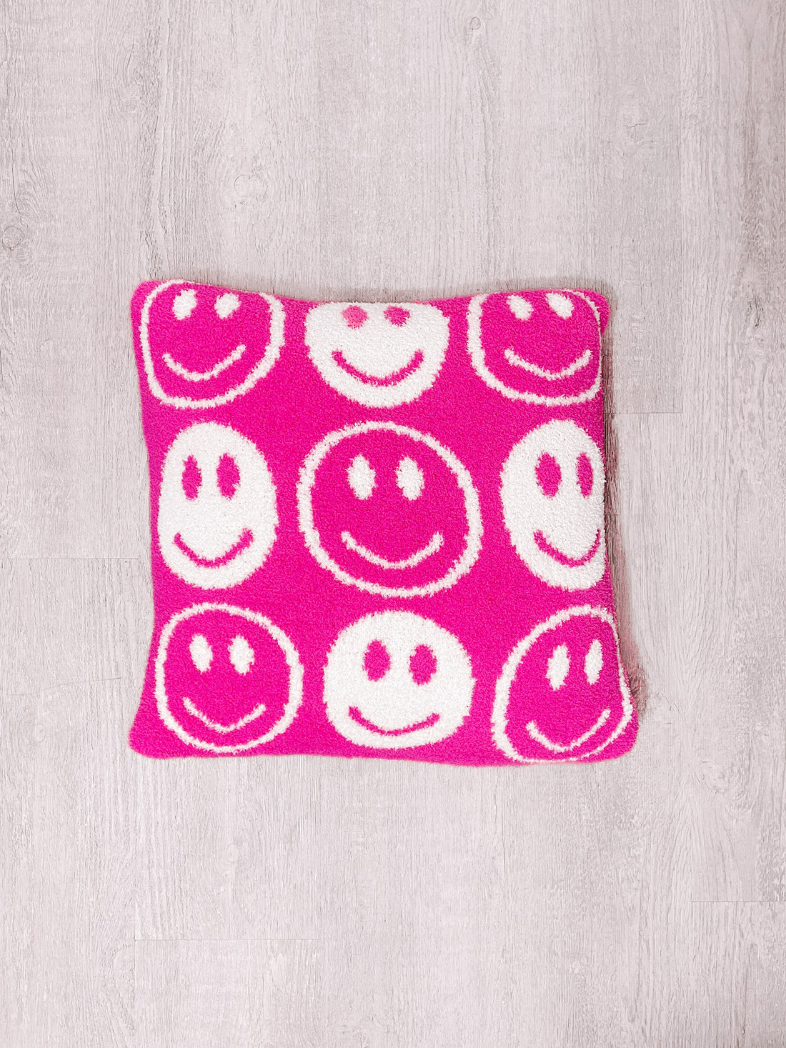 Smiley Dreams Pillow: Pink plush pillow with white smiley faces, perfect for kids.
