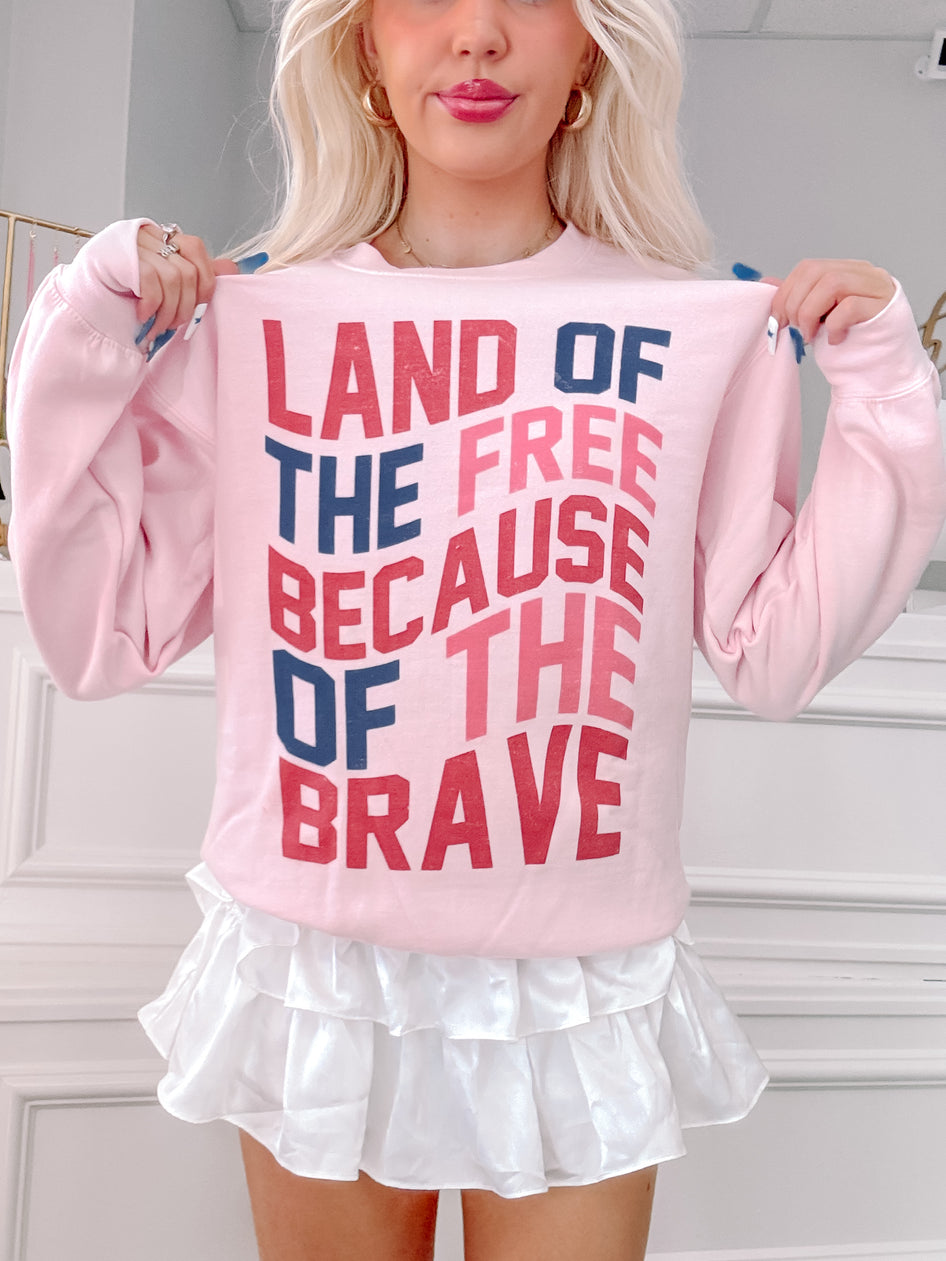 Pink crewneck sweatshirt with patriotic text graphic; woman modeling.
