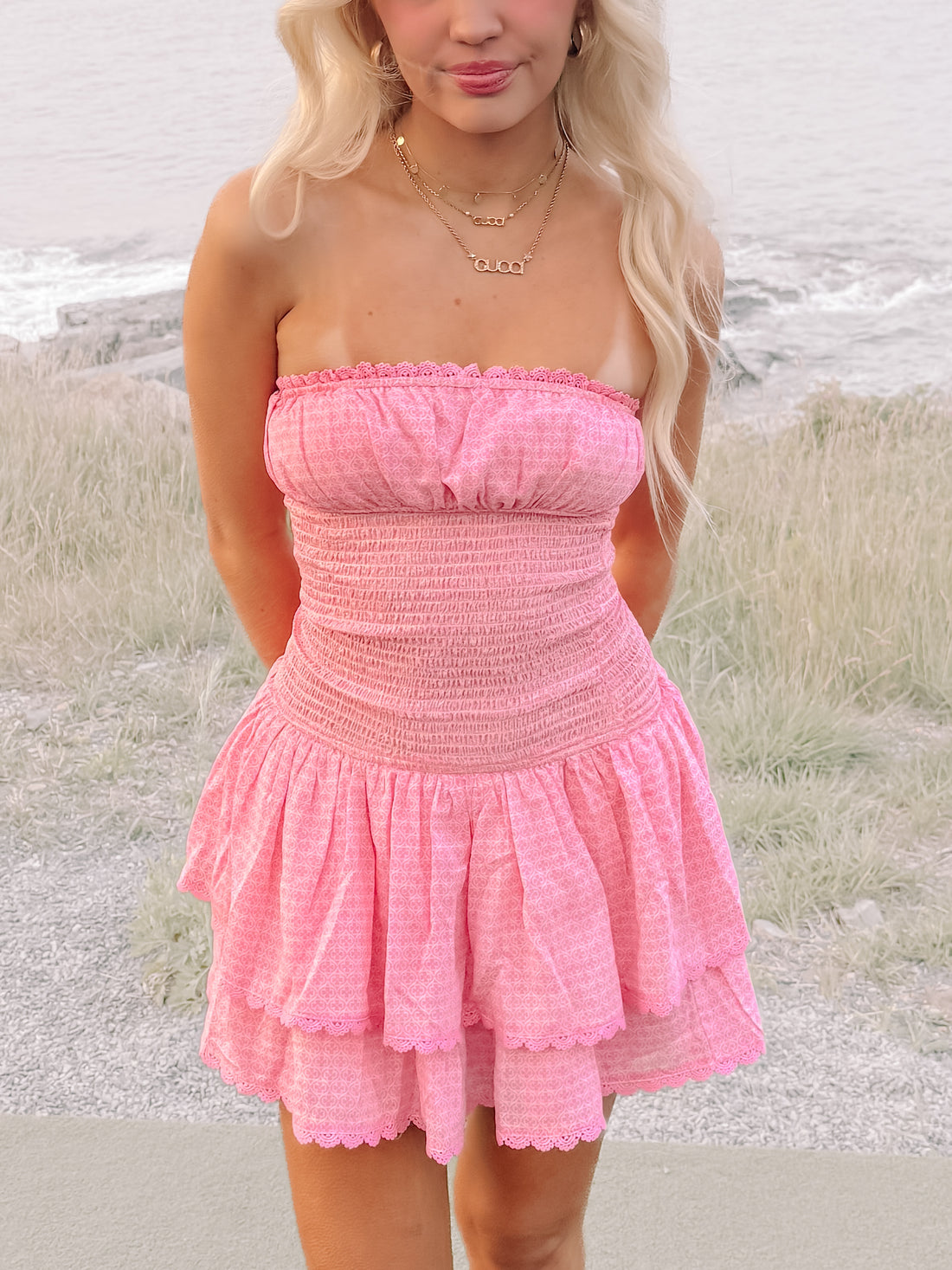 Pink Ocean View Dress: tiered mini dress with smocked bodice and delicate lace trim.
