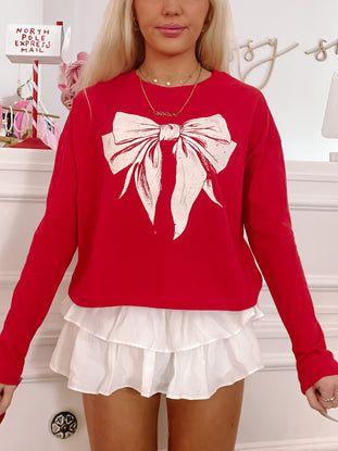 Red Bow Tee: festive red long-sleeve shirt featuring a large white bow graphic.
