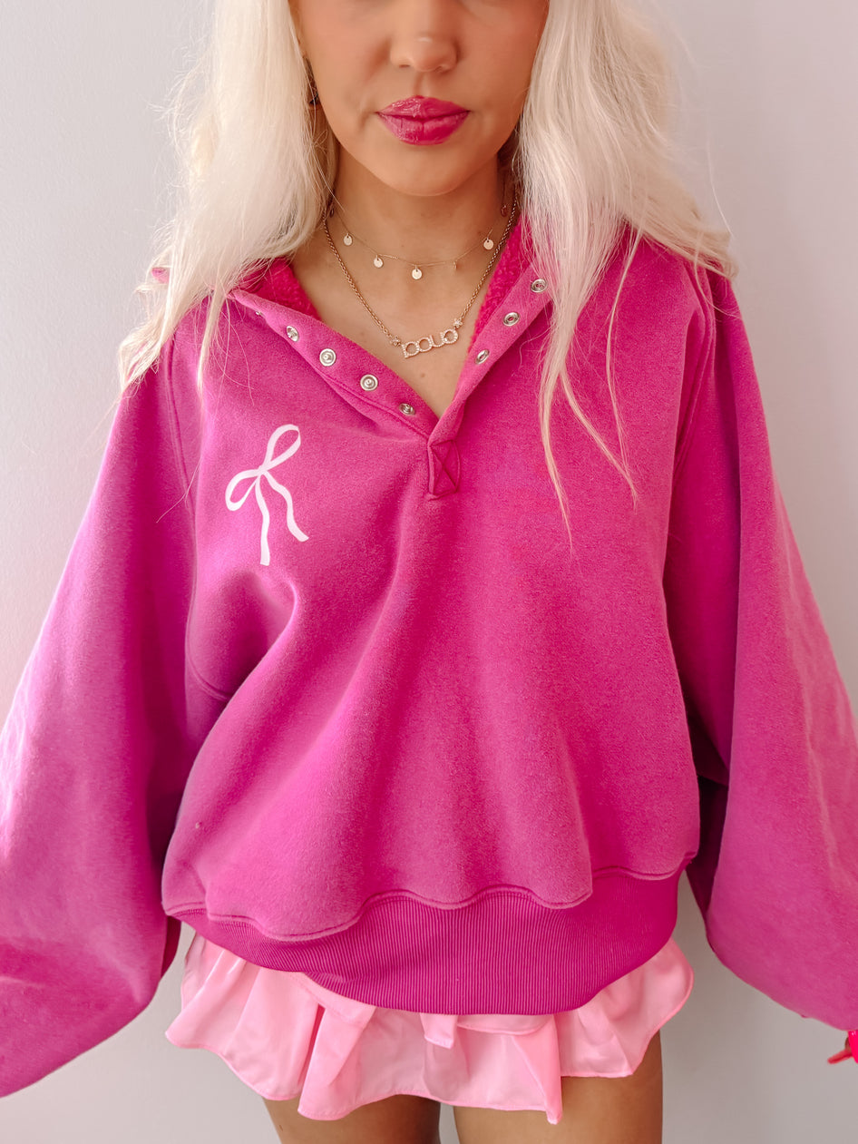 Pink Bow Brynn pullover top with a white bow detail.
