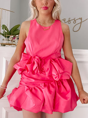 Hot pink mini dress with ruffled detailing, shown on a model.
