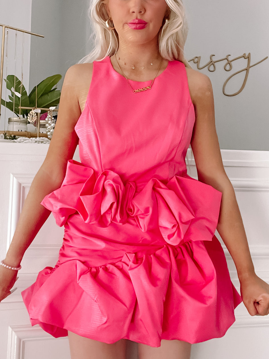 Hot pink mini dress with ruffled detailing, shown on a model.
