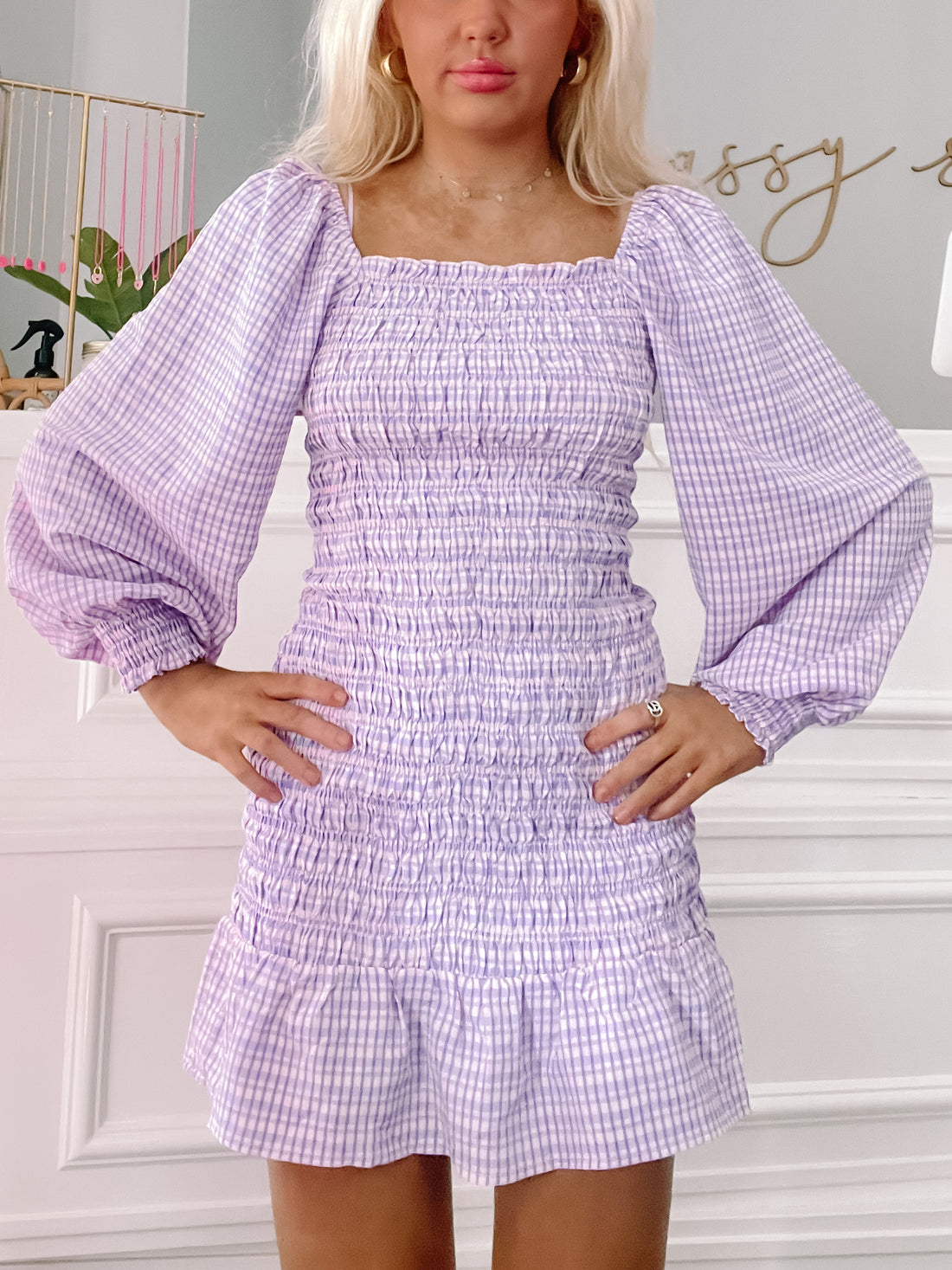 Lavender gingham smock dress with puffed sleeves and a fitted waist.
