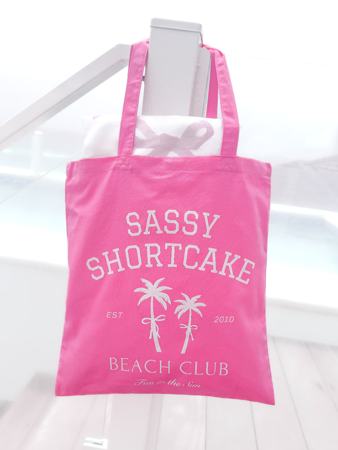 Sassy Shortcake Beach Club Tote Bag: Pink canvas tote with palm tree design, "Fun in the Sun" text.
