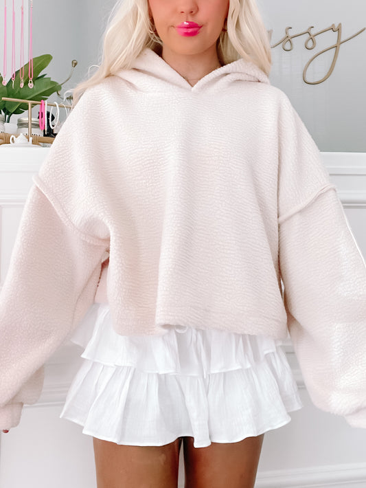 Cream-colored Bear Hug Pullover, oversized fit, soft fleece fabric.
