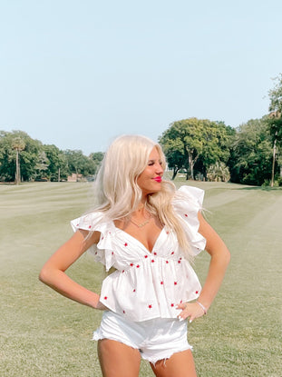 White star-print peasant top, worn outdoors on a golf course.
