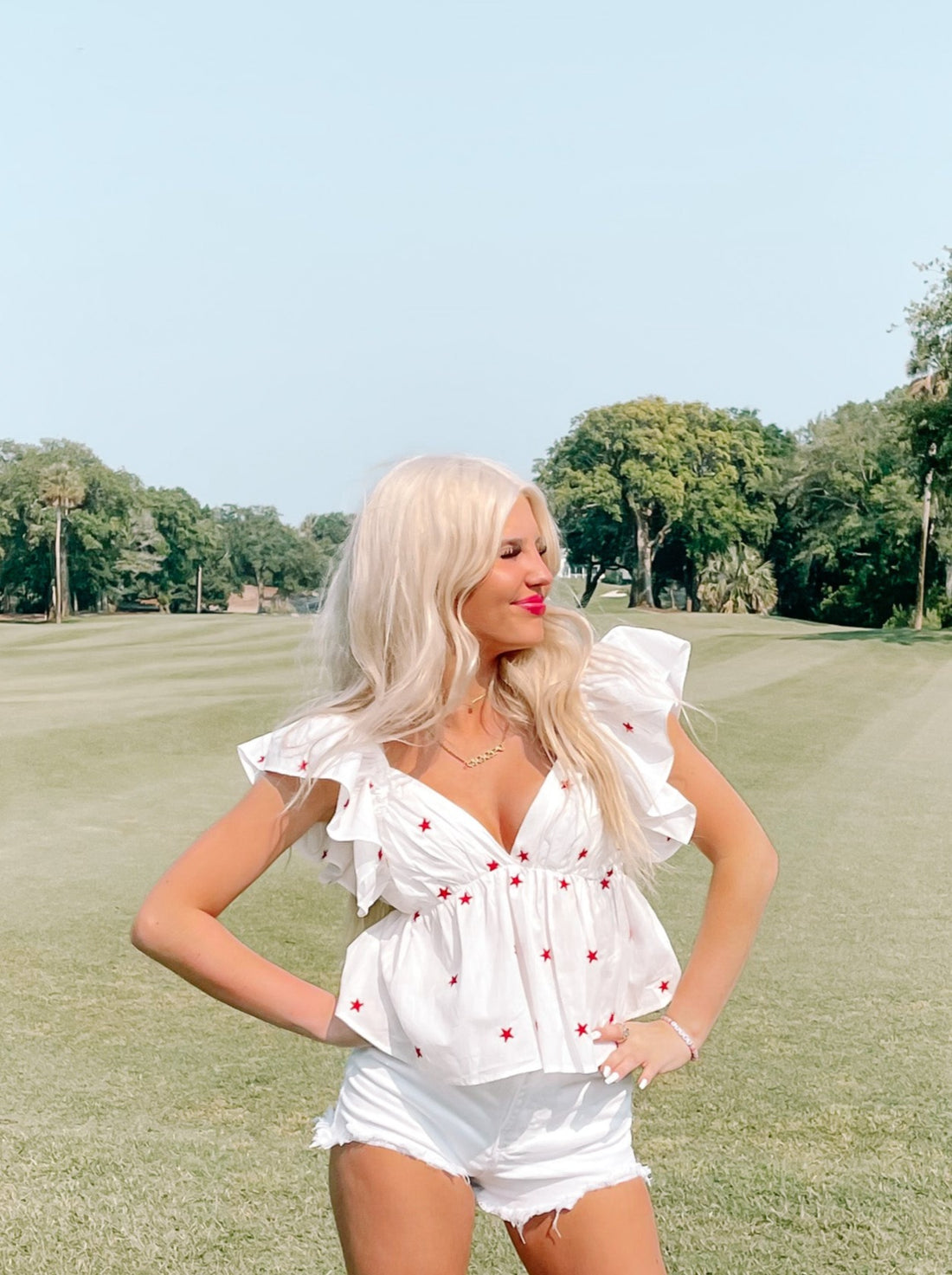 White star-print peasant top, worn outdoors on a golf course.
