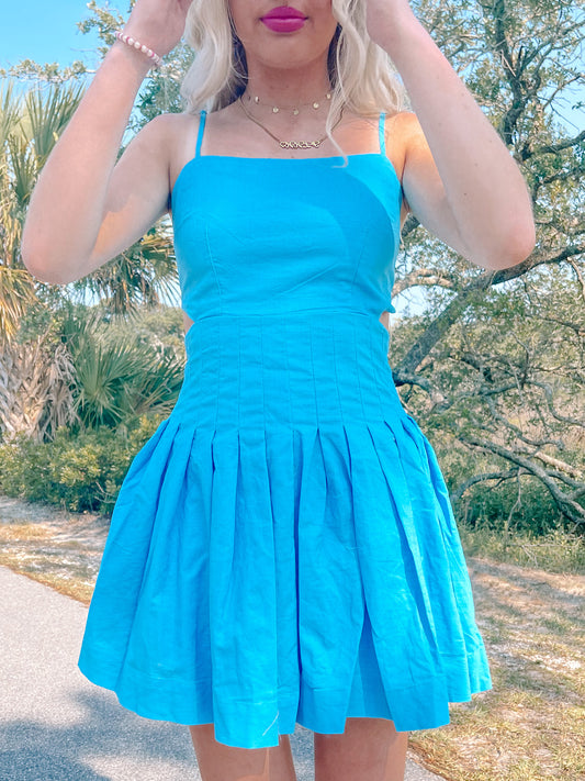 Bright blue pleated mini dress outdoors; summer fashion.