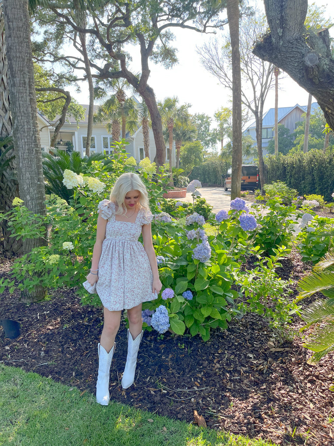 Floral print mini dress styled outdoors amongst hydrangeas.
