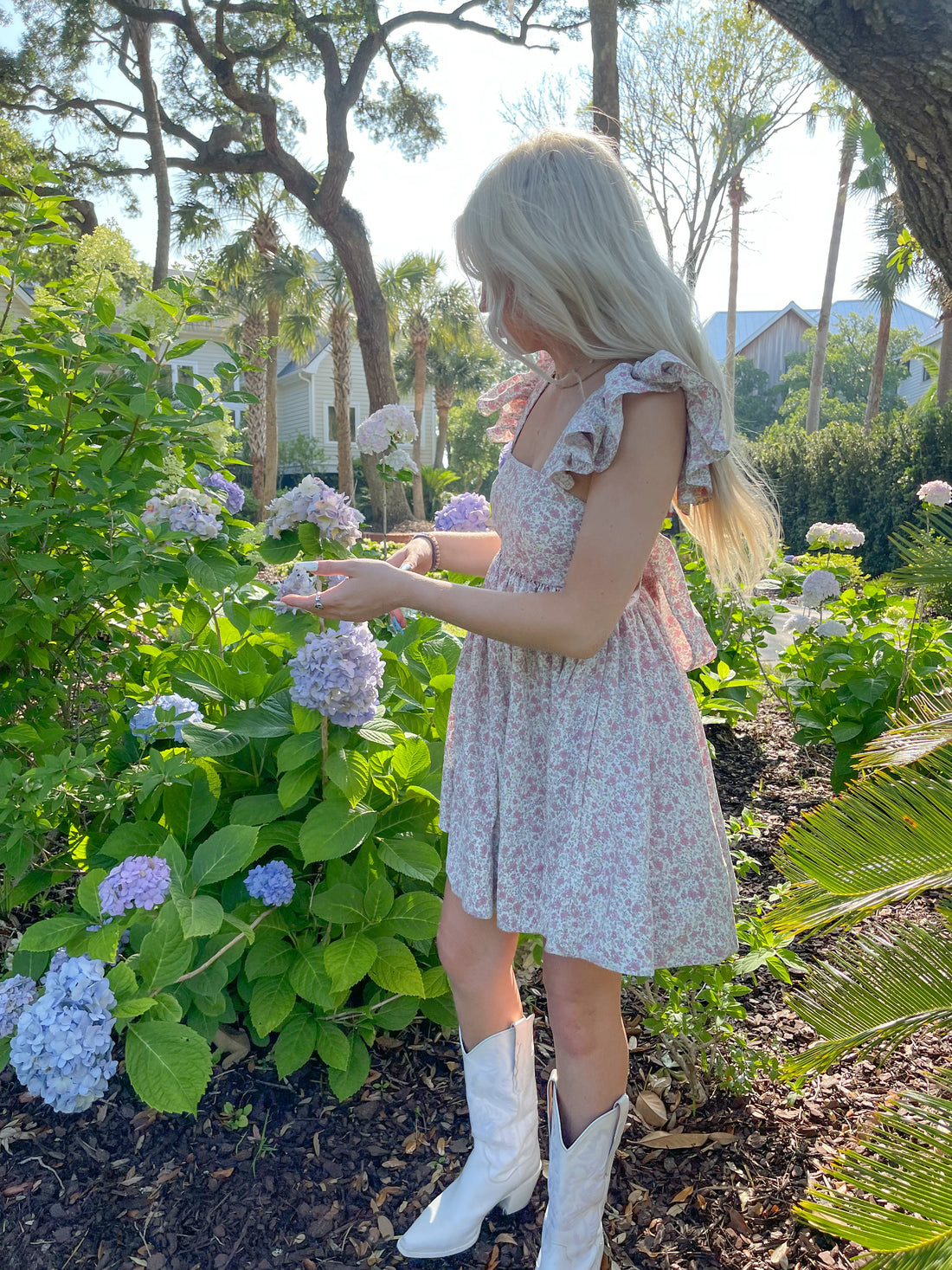 Floral dress styled outdoors amongst blooming hydrangeas.
