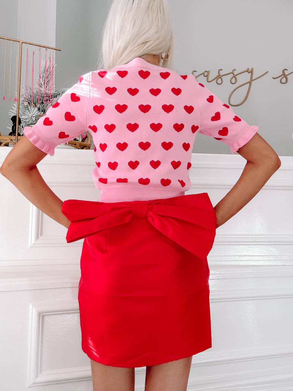 Red mini skirt with oversized bow detail, perfect for Valentine's Day.

