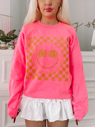 Pink Pumpkin Smiley Crewneck sweatshirt with gold checkered design
