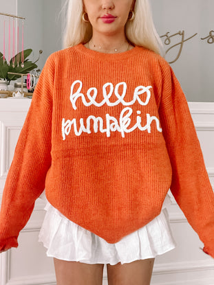 Orange Hello Pumpkin sweater with white embroidered lettering.
