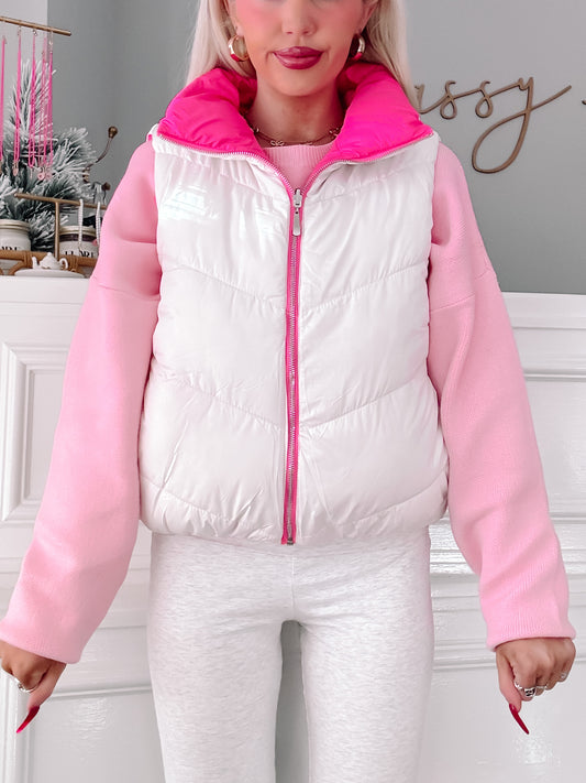 White and pink puffer vest with zipper closure, modeled over a pink sweater.