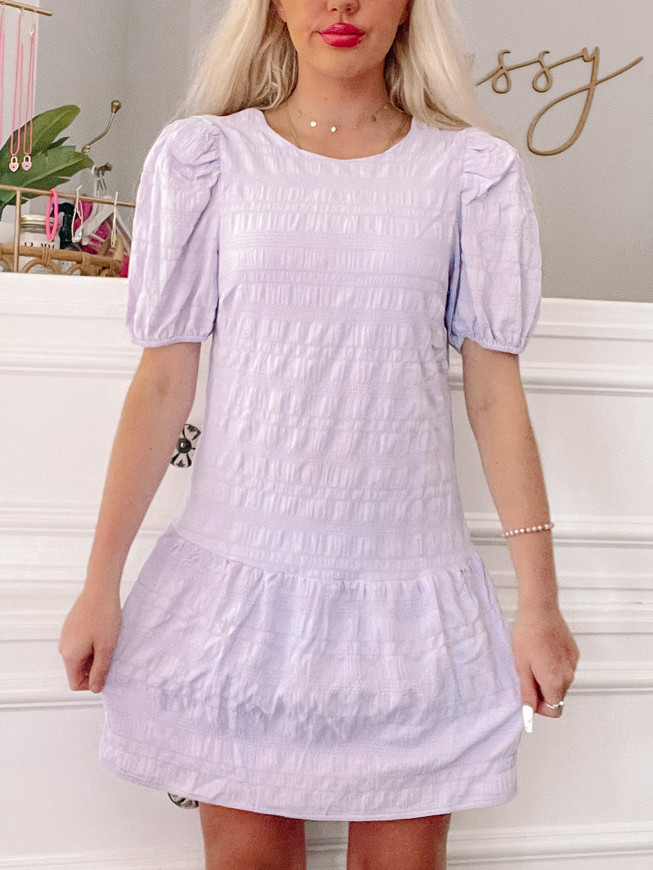 Lavender puff-sleeve mini dress with tiered ruffle hem.
