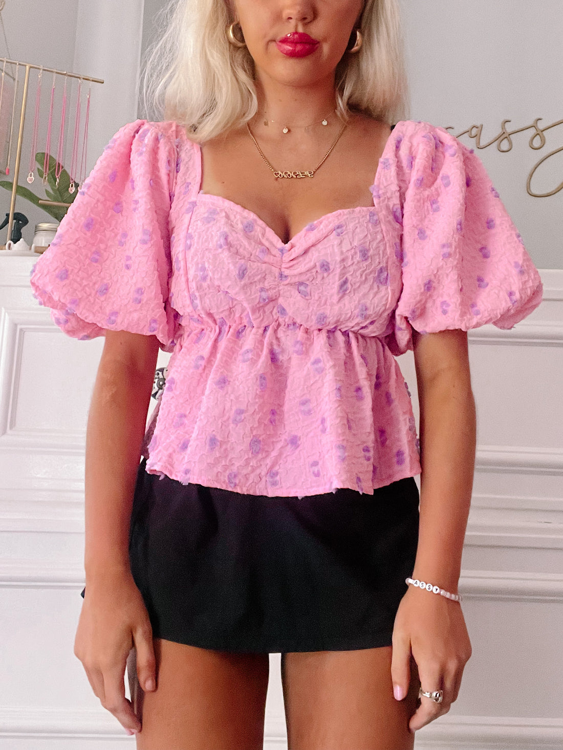 Pink puff-sleeve top with purple floral print; square neck, fitted waist.
