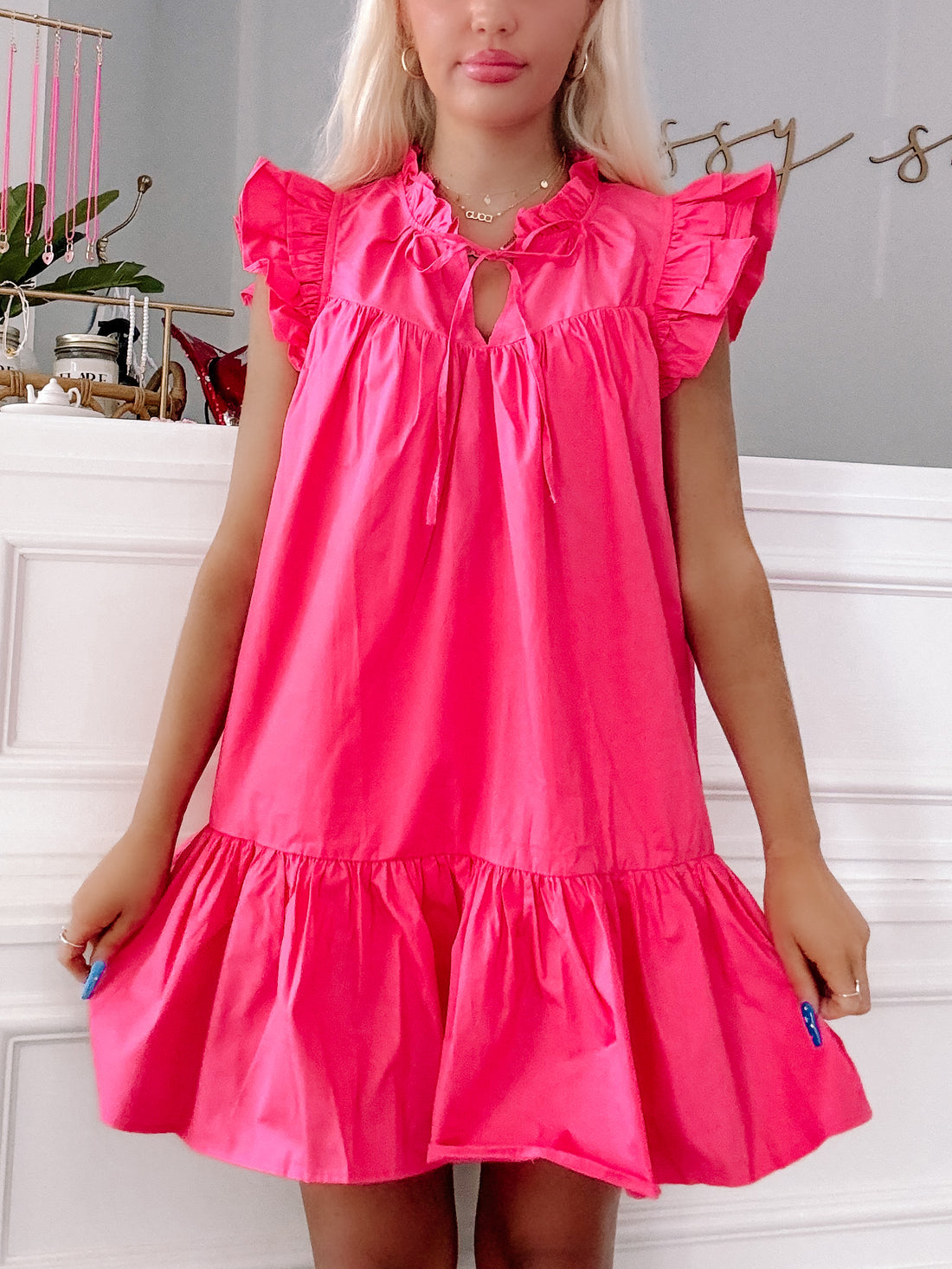Rose pink "Dressed to Impress" mini dress with ruffle sleeves and tiered skirt.
