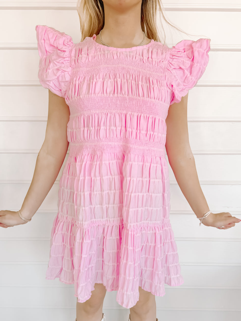 Pink smocked mini dress with puff sleeves; perfect for summer.

