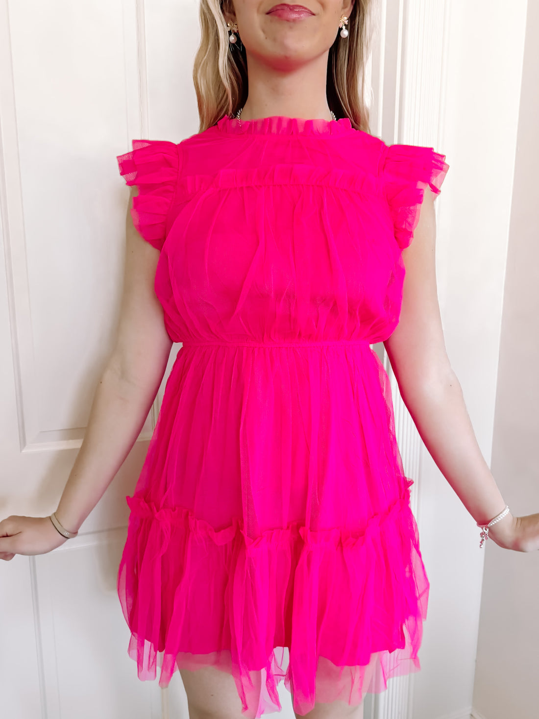 Hot pink tulle mini dress with ruffle details.
