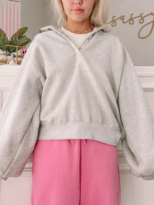 Grey pullover sweatshirt with balloon sleeves, modeled against a light background.
