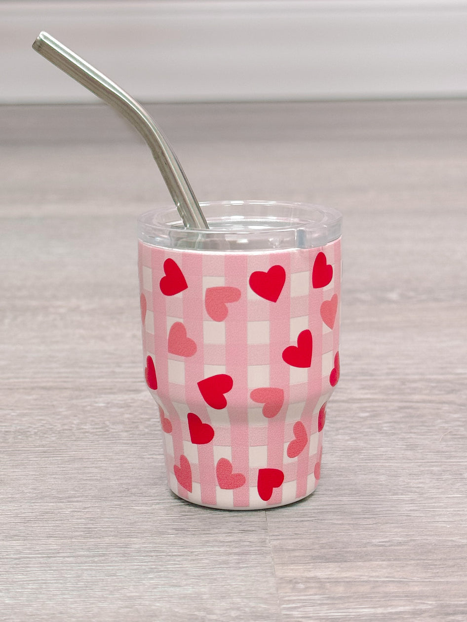 Pink tumbler with hearts and gingham print, includes stainless steel straw.
