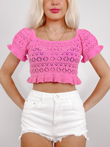 Woven Wonders Top: Pink crochet crop top with puff sleeves and ruffled hem.
