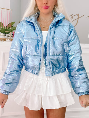 Metallic blue puffer jacket, cropped style.
