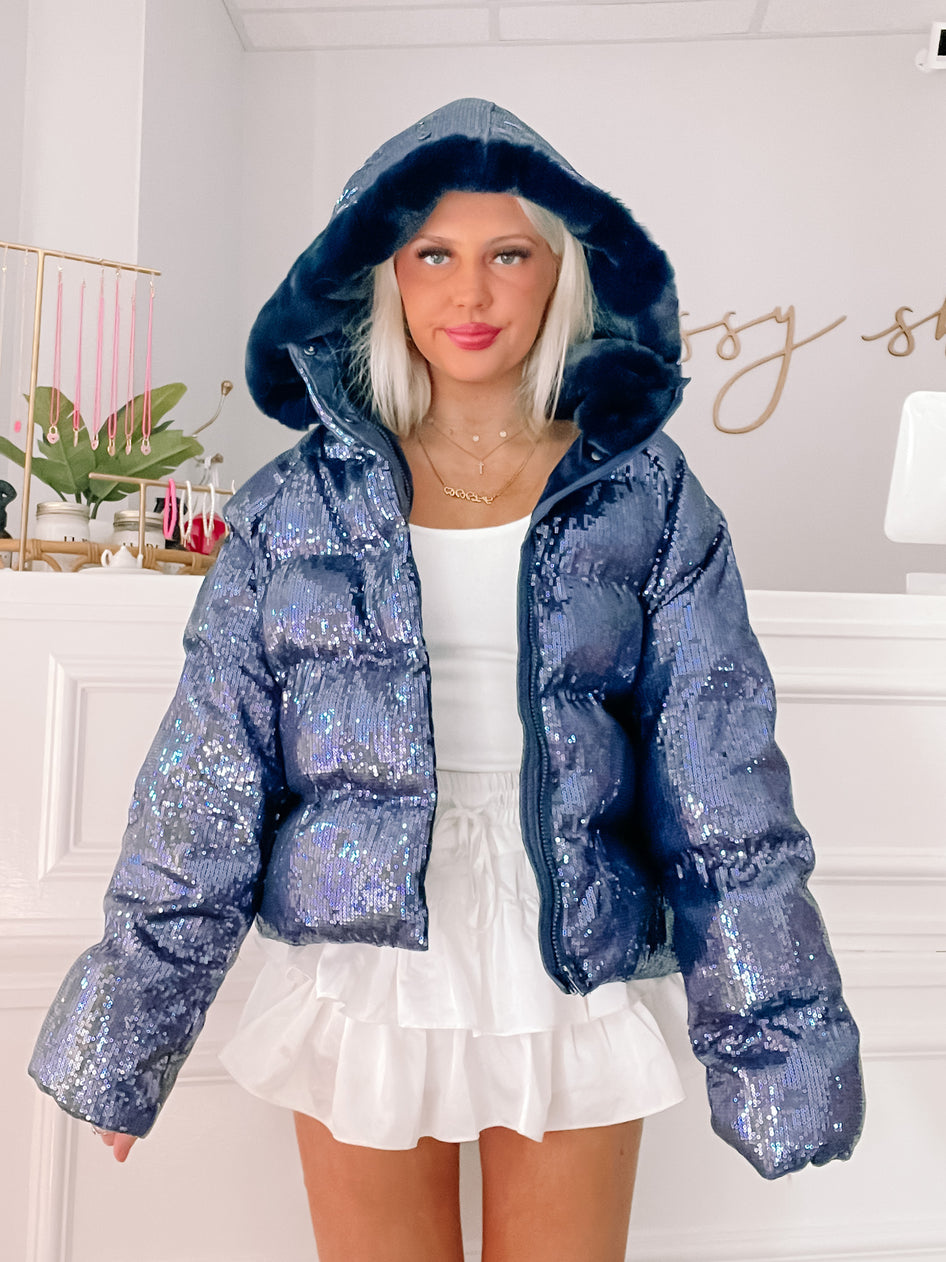 Sequin puffer jacket with faux fur hood, navy blue, for a stylish night out.
