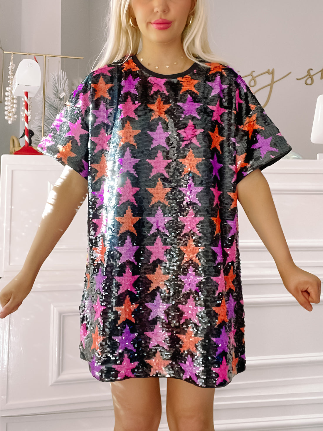 Sequin mini dress with colorful star pattern; short sleeves, shown on model.
