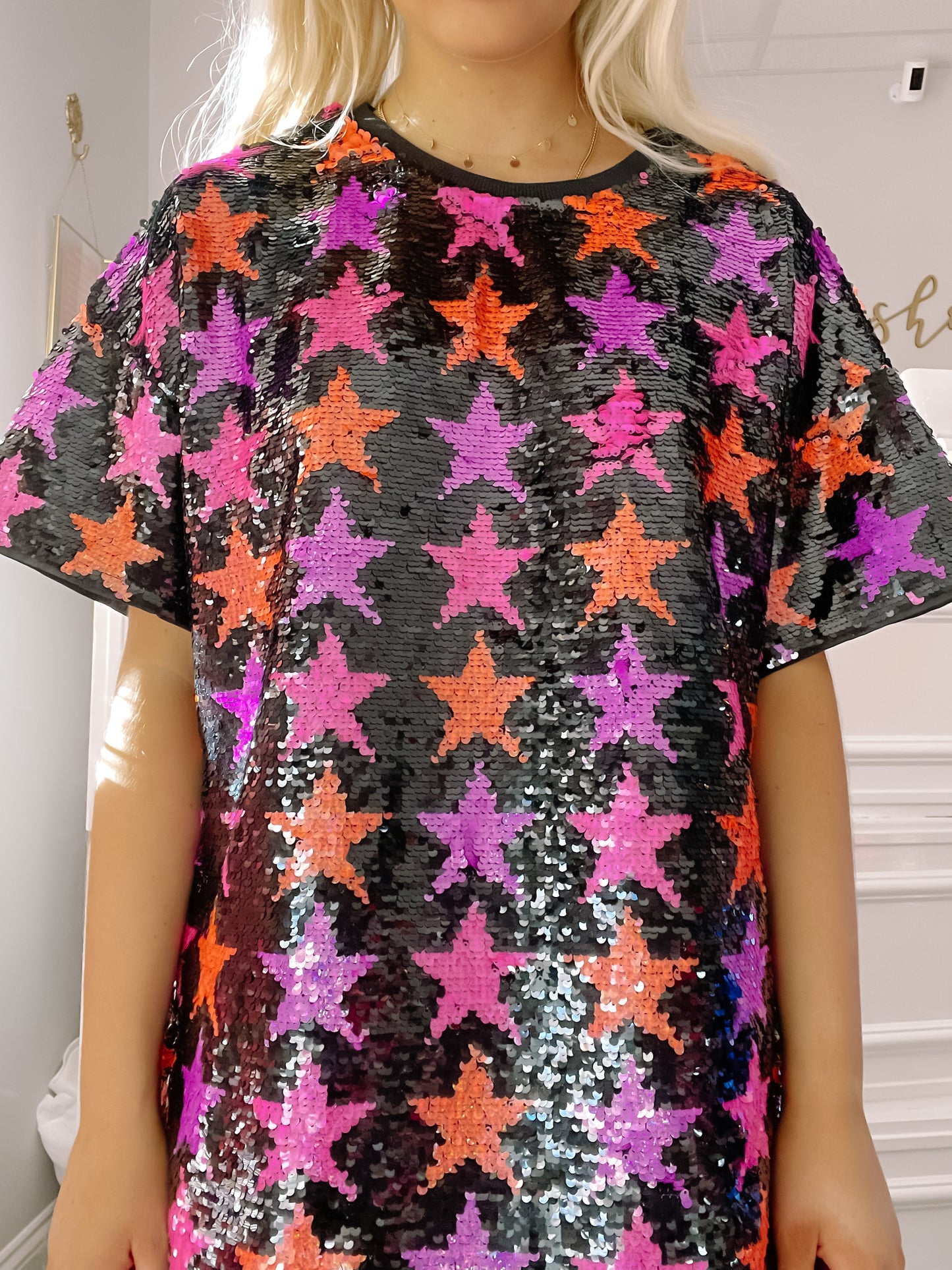 Sequin mini dress; pink, purple & orange stars on black, short sleeves.
