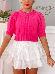 Hot pink cropped knit sweater with eyelet detailing, paired with a white tiered ruffle mini skirt. Left on Pink Top from Sassy Shortcake

