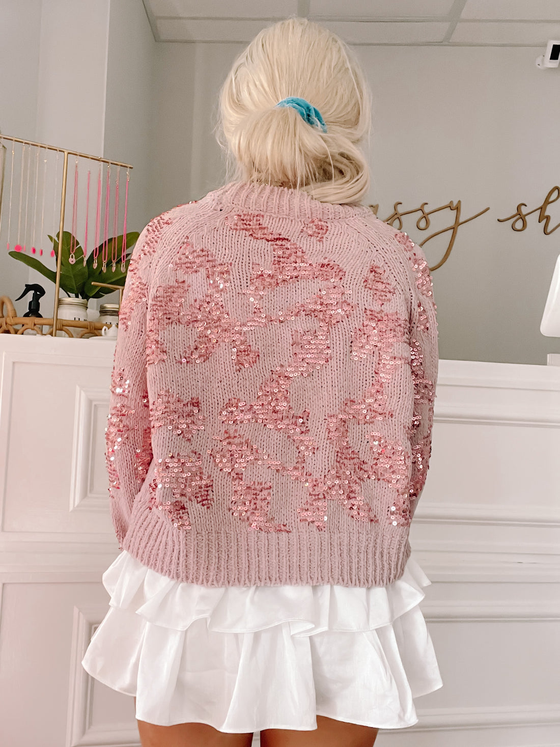 Pink sequined cheetah-print sweater, worn with a white ruffled skirt.
