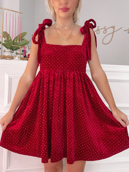 Red velvet mini dress with sparkly accents and tie straps.
