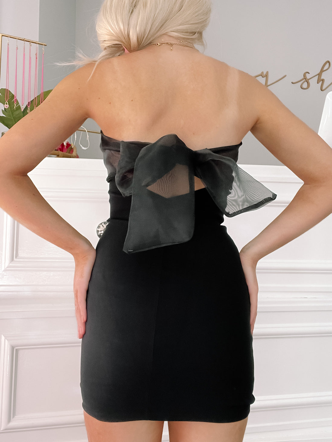 Black mini dress with sheer bow detail; rear view.
