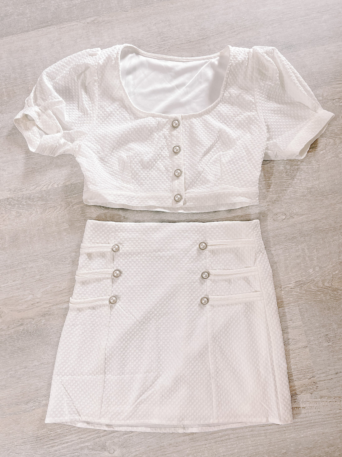 White textured two-piece outfit:  cropped button-front top & mini skirt.
