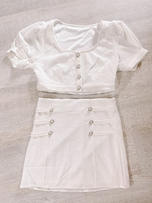 White textured two-piece outfit:  cropped button-front top & mini skirt.
