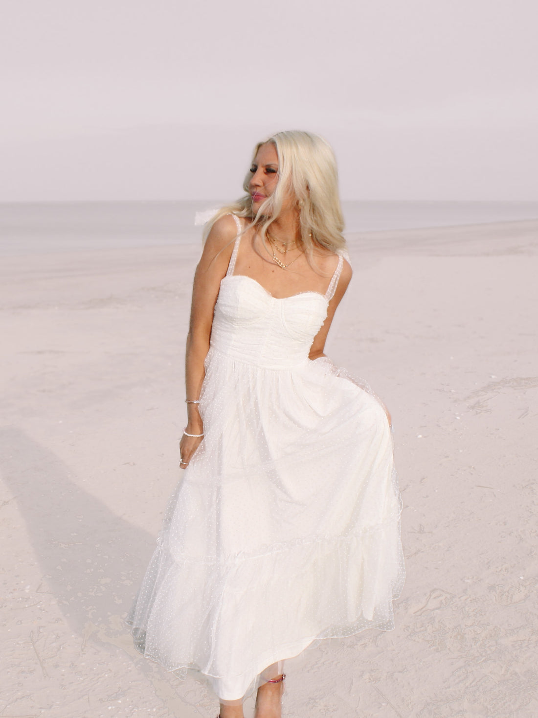 White polka dot midi dress on a beach
