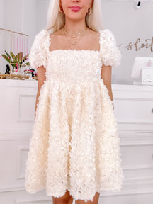 Off-white floral 3D textured mini dress with puff sleeves.
