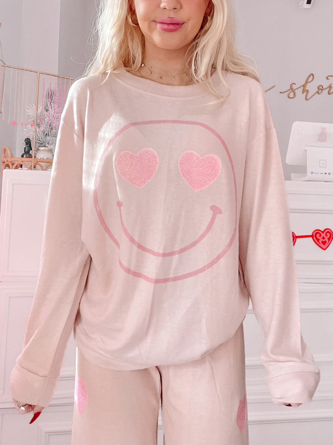 Cozy blush pink pajama set featuring a smiley face with heart eyes; perfect for Valentine's Day.

